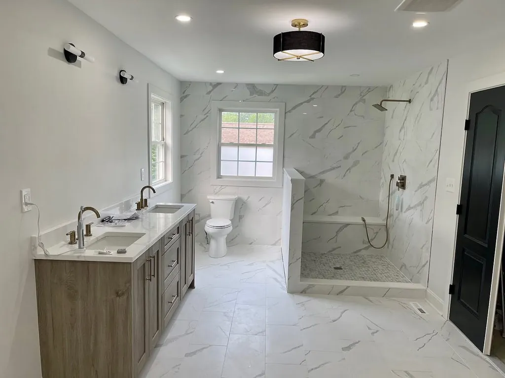 Completed bathroom remodel with large-format stone tile and walk-in shower by Delpa Builders